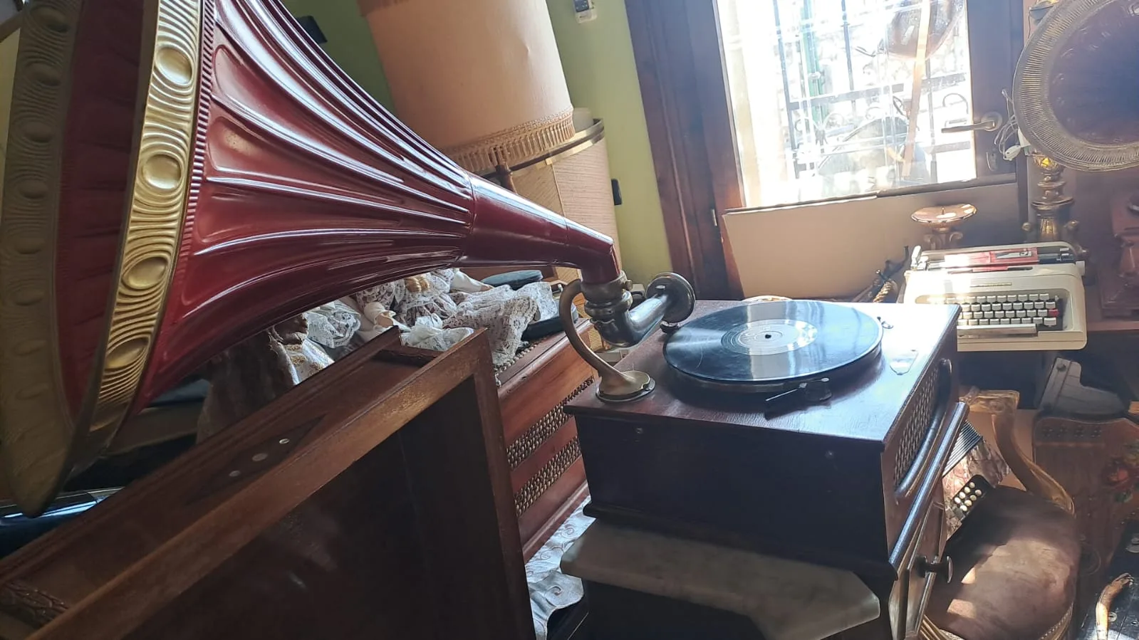 Grammofono a tromba con padiglione bordeaux e giradischi d'epoca nel negozio di Ospedaletto d'Alpinolo