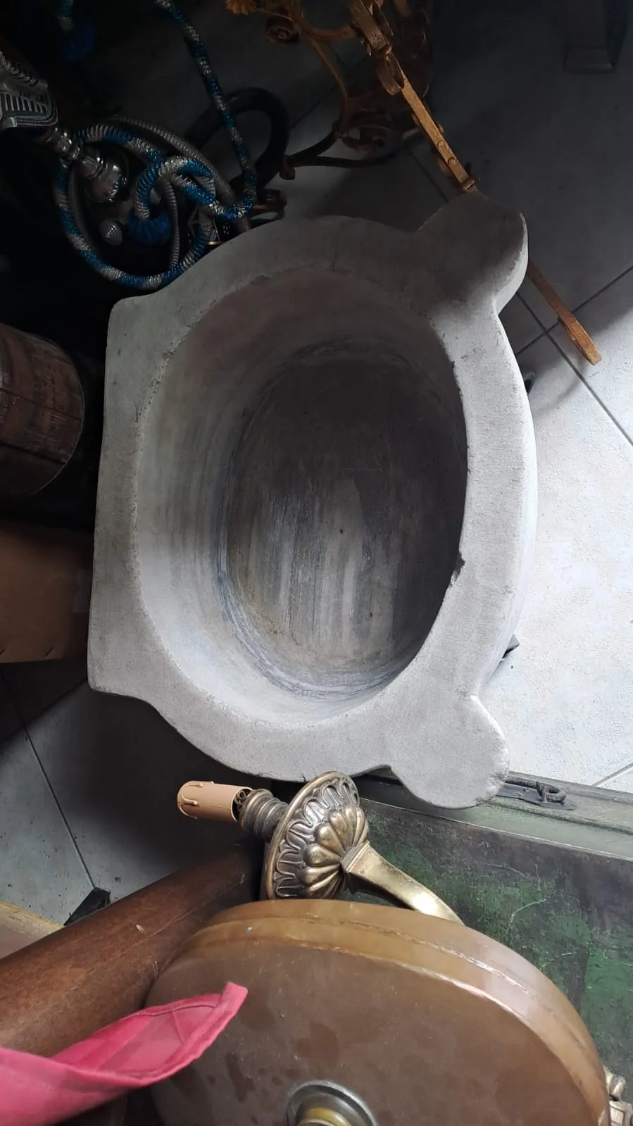Acquasantiera in marmo grigio vista dall'alto, con vasca ovale e due piccole anse laterali