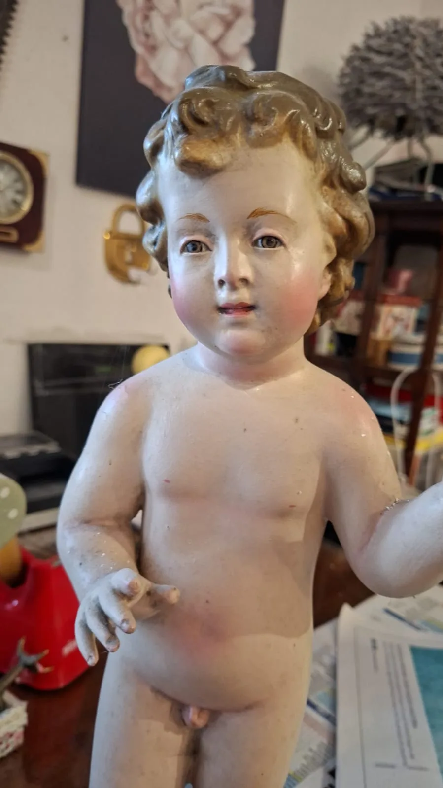 Statua di bambinello in terracotta dipinta con riccioli dorati e guance rosate