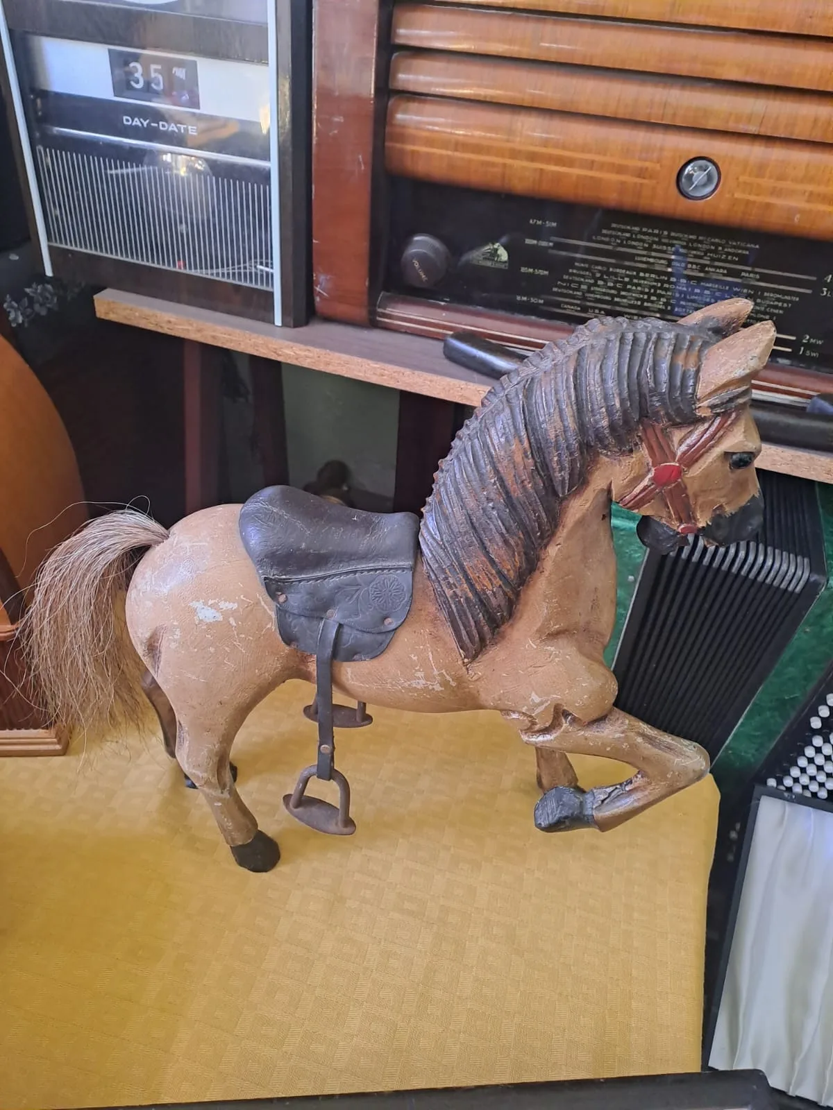 Cavallino in legno intagliato e dipinto, con sella in cuoio e criniera in crine