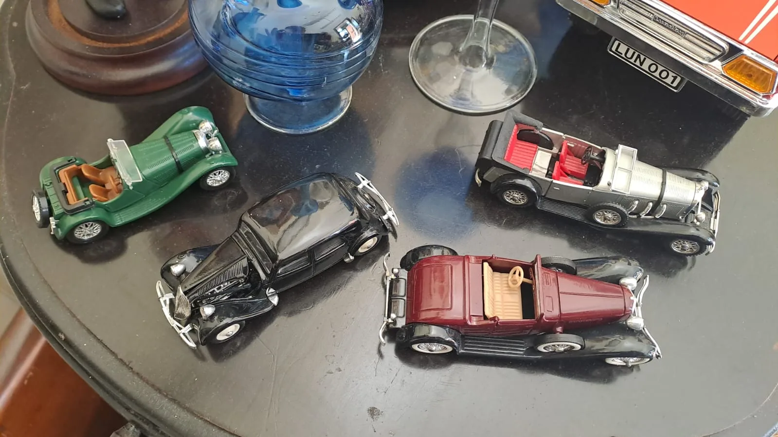 Modellini di auto d'epoca: spider verde, berlina nera, torpedo bordeaux e argento
