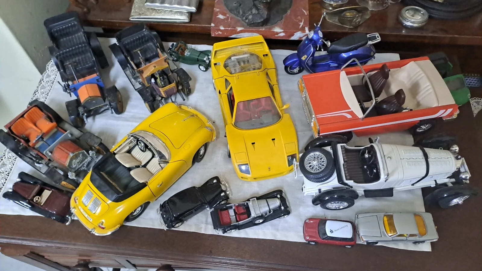 Collezione di modellini d'auto da collezione: auto d'epoca, spider gialla, Ferrari gialla, cabriolet e una Vespa blu