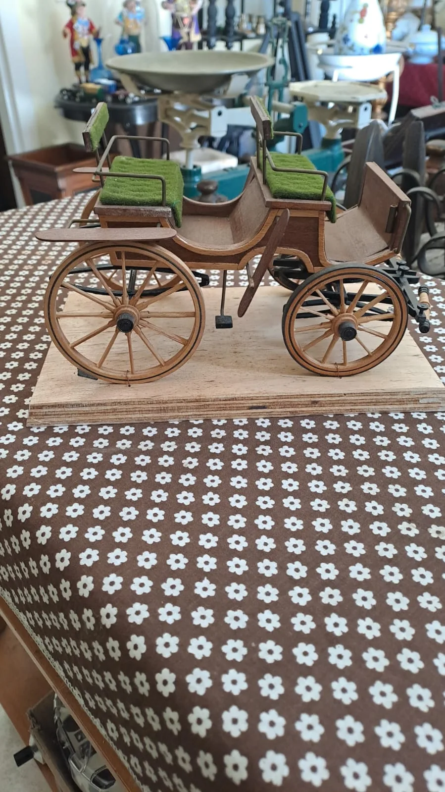 Modellino di carrozza in legno con ruote a raggi e sedili in panno verde, su base in legno