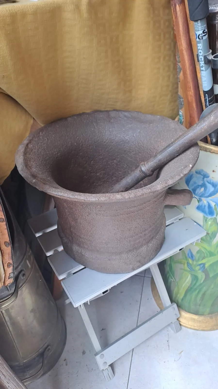 Grande mortaio in ghisa con pestello, dal bordo svasato e un'ansa laterale