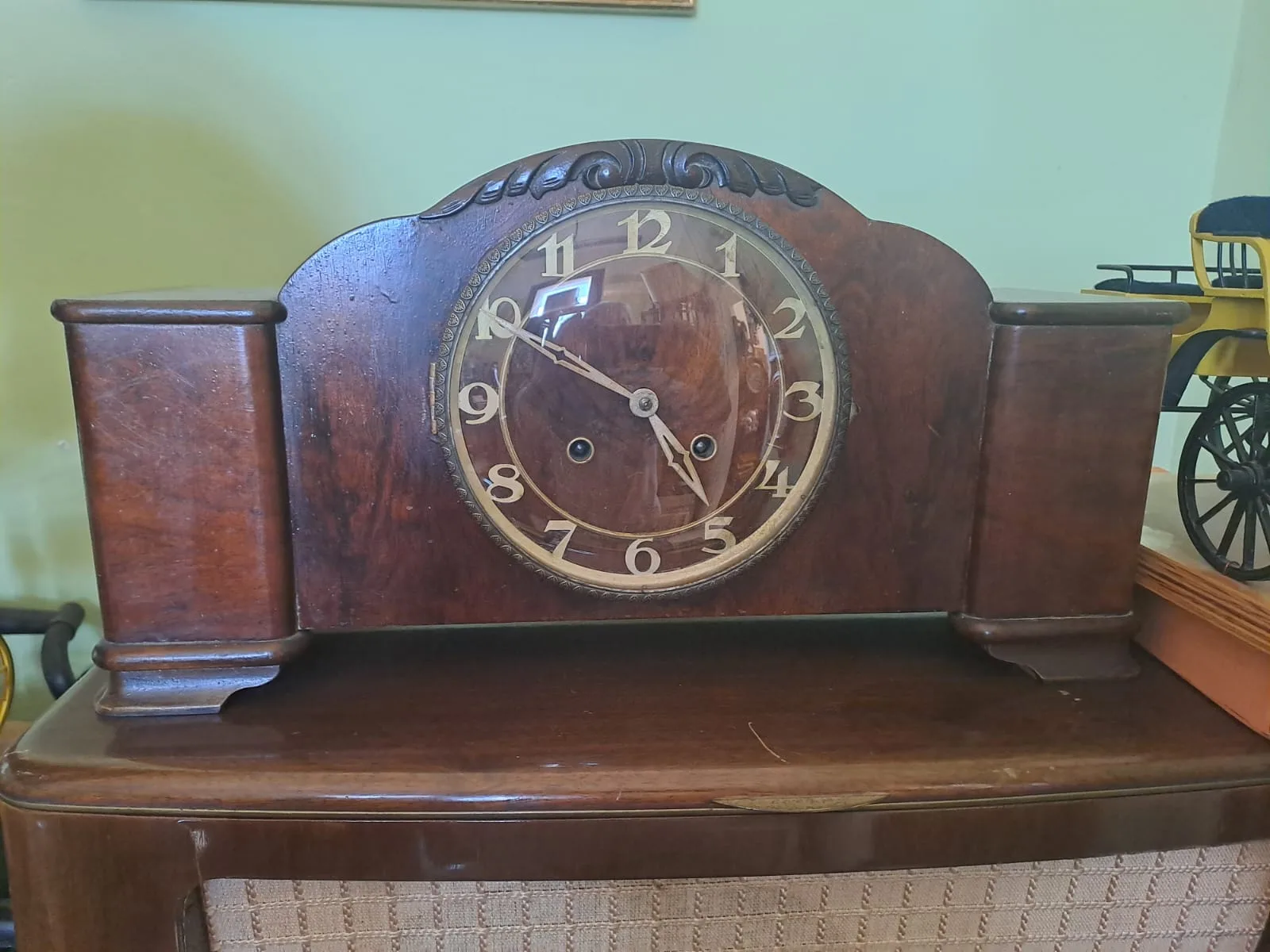 Orologio da camino in noce con cimasa intagliata e quadrante dorato