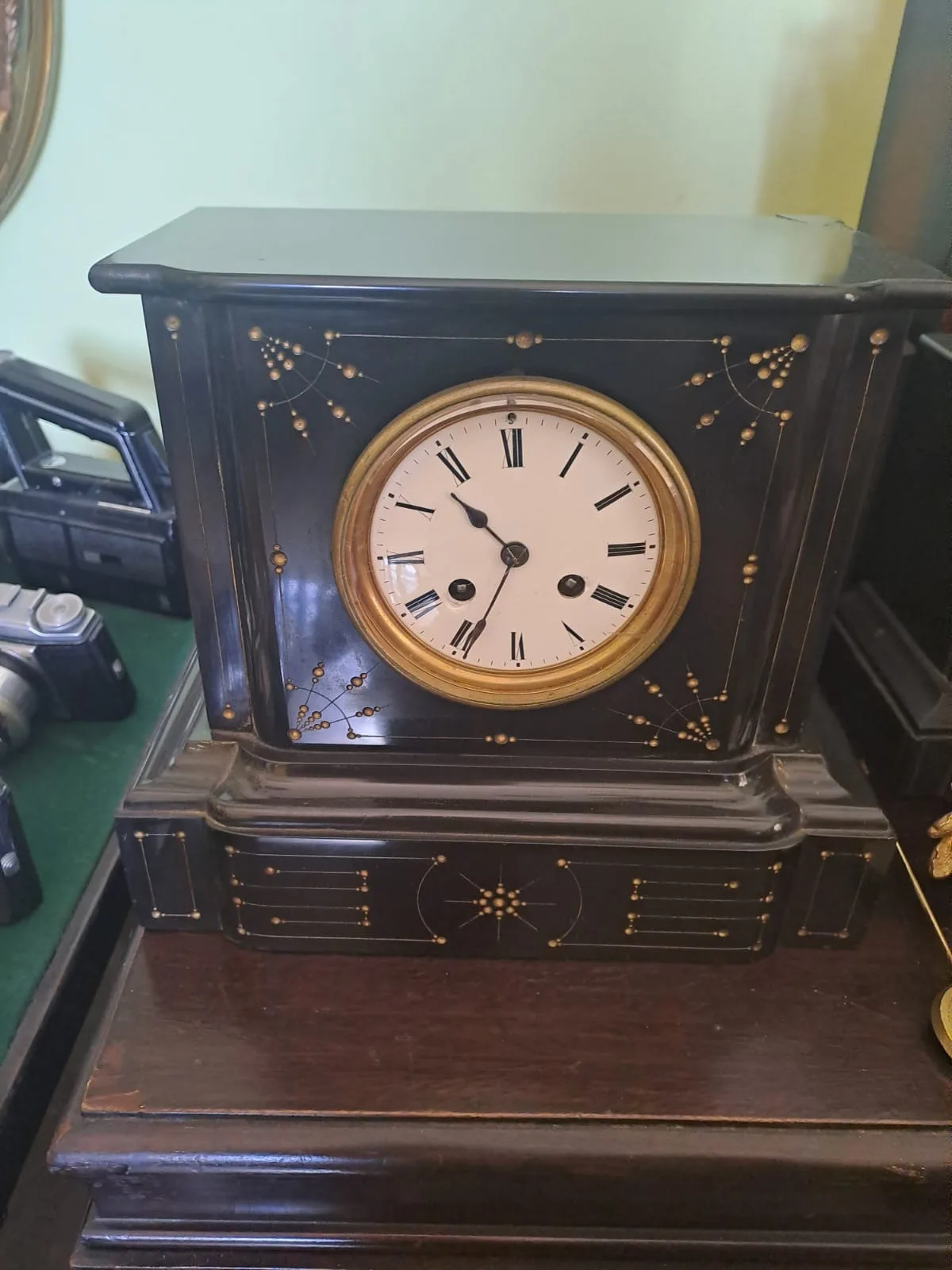 Orologio da camino in marmo nero con filetti dorati e quadrante a numeri romani