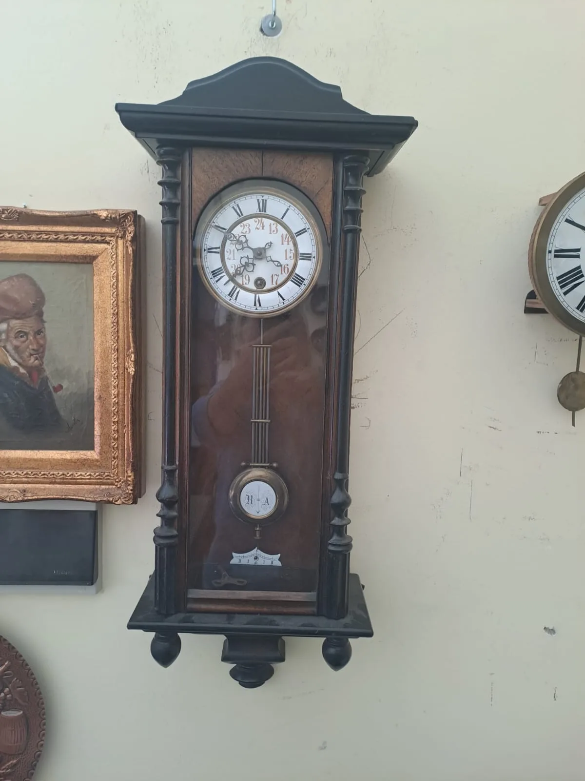 Orologio a pendolo da parete in noce con colonnine tornite e quadrante smaltato